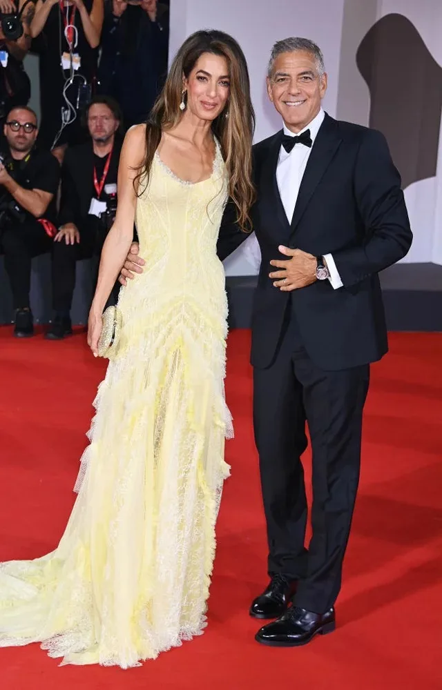 Amal Clooney en robe Atelier Versace et chaussures Aquazzura et George Clooney en costume Giorgio Armani